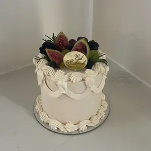 Cream Eid cake with vintage piping, topped with figs and berries