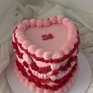Pink heart cake with red and pink piping on white chiffon