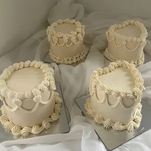 Four small cream vintage cakes on white fabric