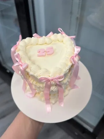 Ivory heart mini cake with a pink ‘25’ and pink ribbon bows