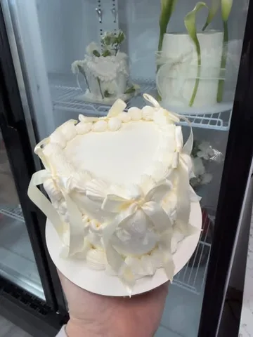 Ivory heart mini cake with shell piping and ivory ribbon bows
