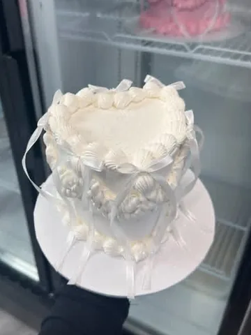 All-white heart mini cake with shell piping and white ribbons